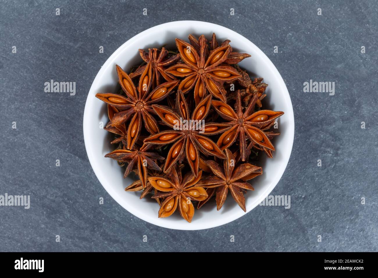 Star anise star-anise Christmas spice herb from above bowl on a slate Stock Photo