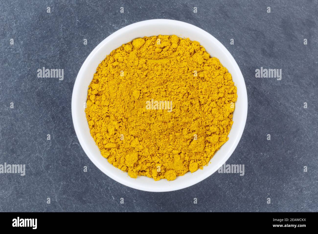 Curry powder spice from above bowl on a slate Stock Photo