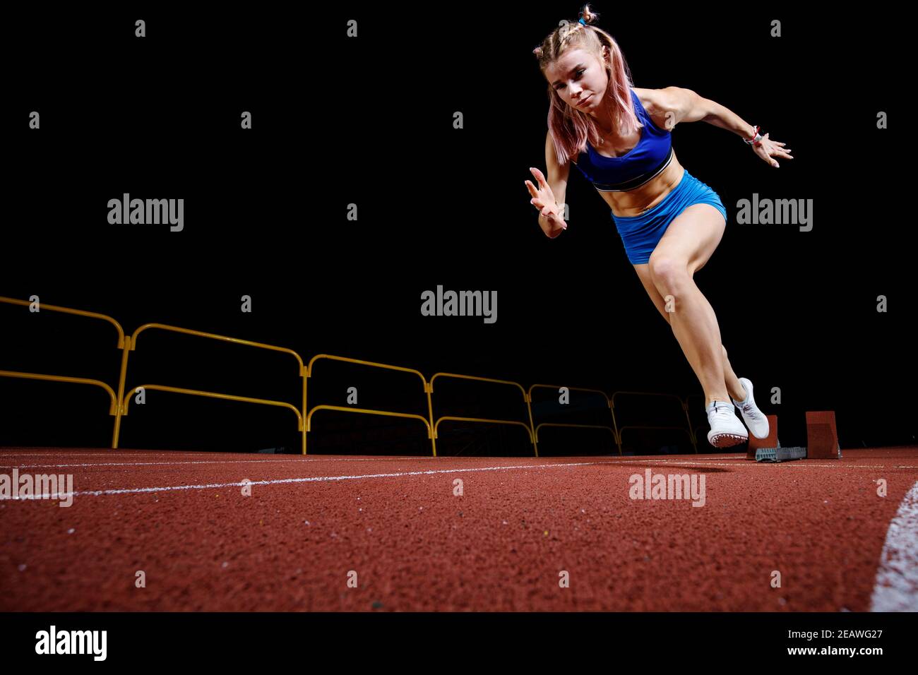 Female track runner bursting off starting block Stock Photo Alamy