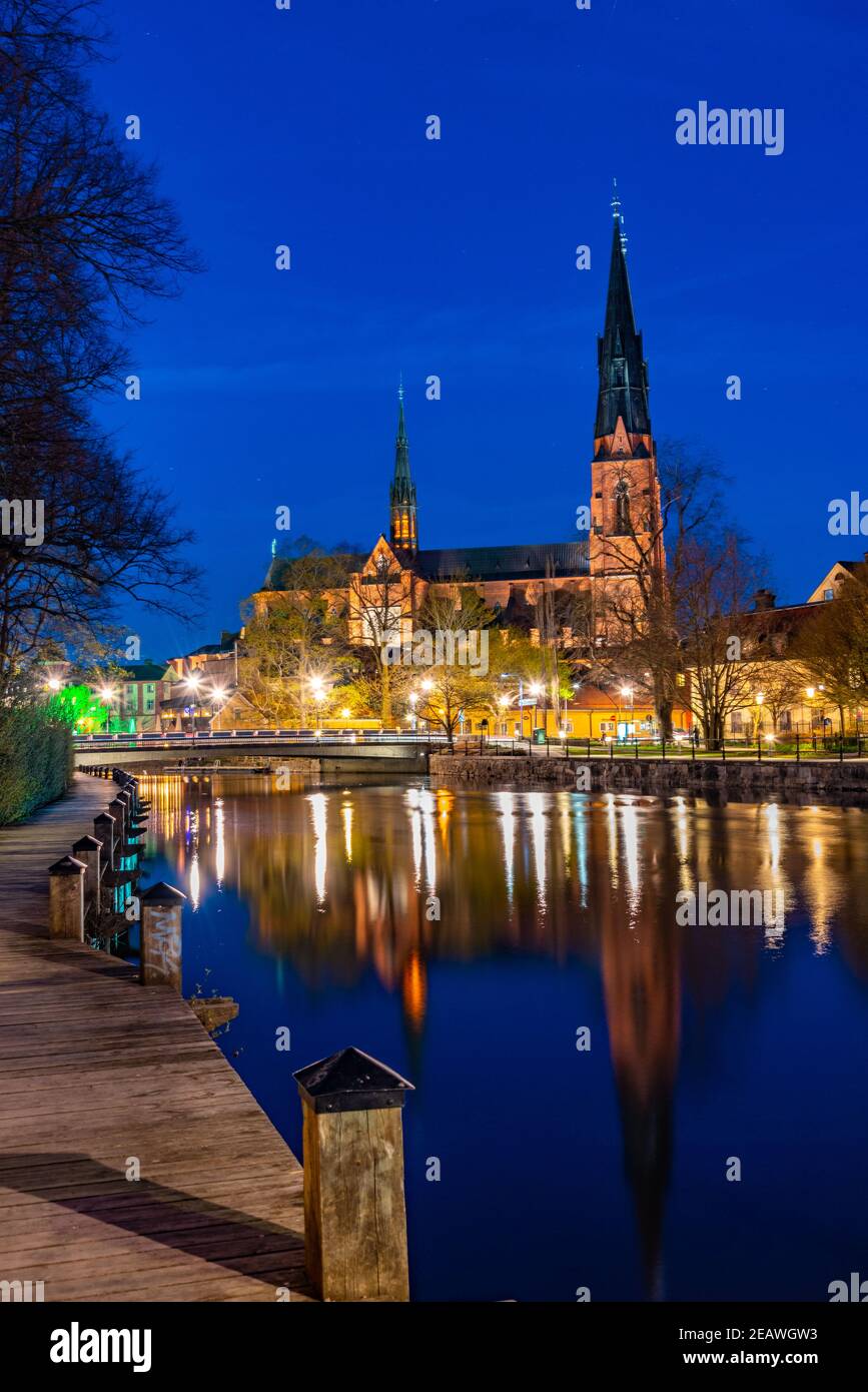 Sunset view of Uppsala cathedral reflecting on river Fyris in Sweden