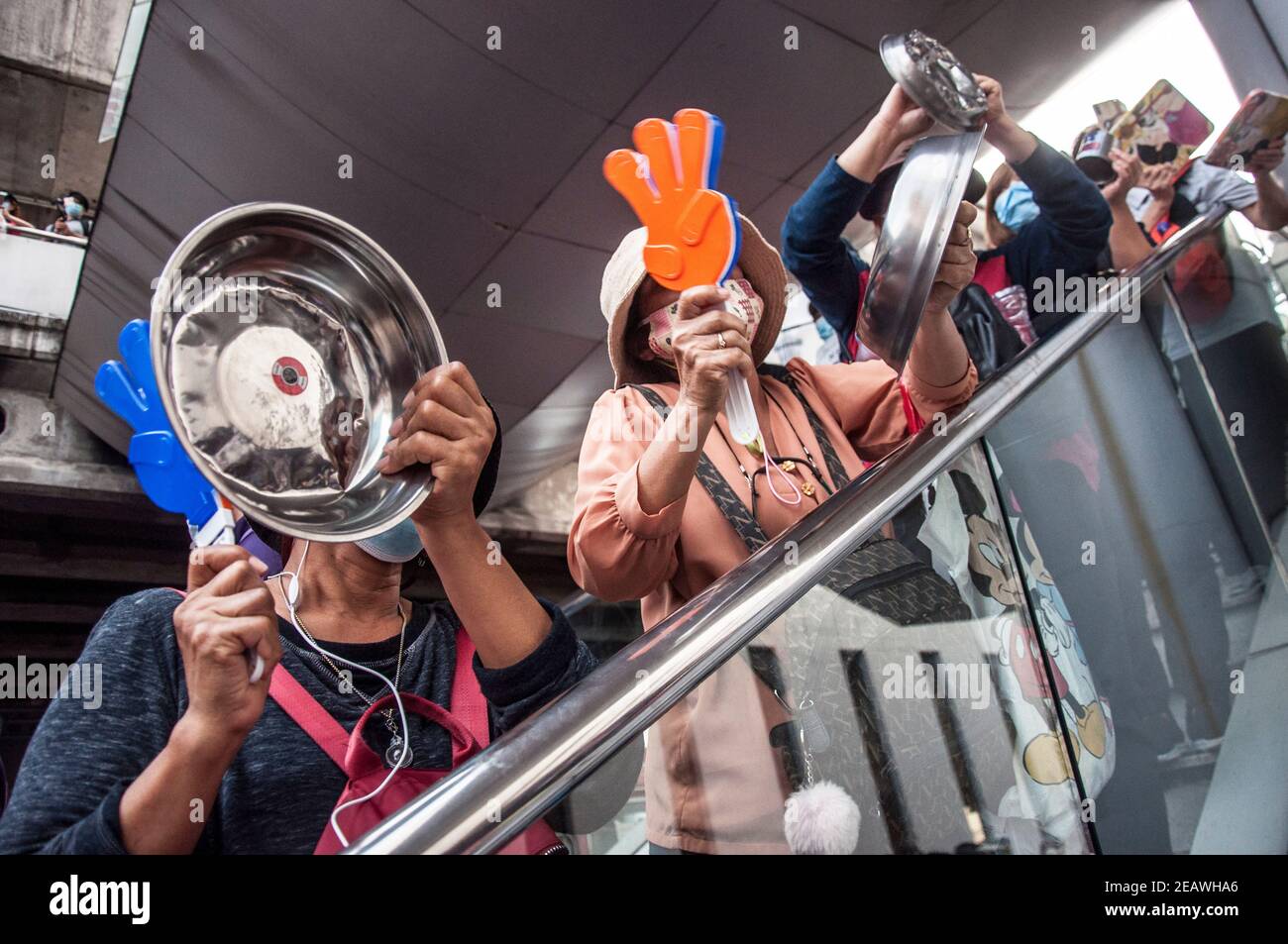 Pro-democracy protesters banging  saucepans during the demonstration.Pro-democracy protesters and activists attend a rally by banging kitchen utensils to protest against the government and demanding to abolish the lese majesty law (article 112 of the Thai criminal code) at Bangkok Art and Culture Center (BACC). Stock Photo