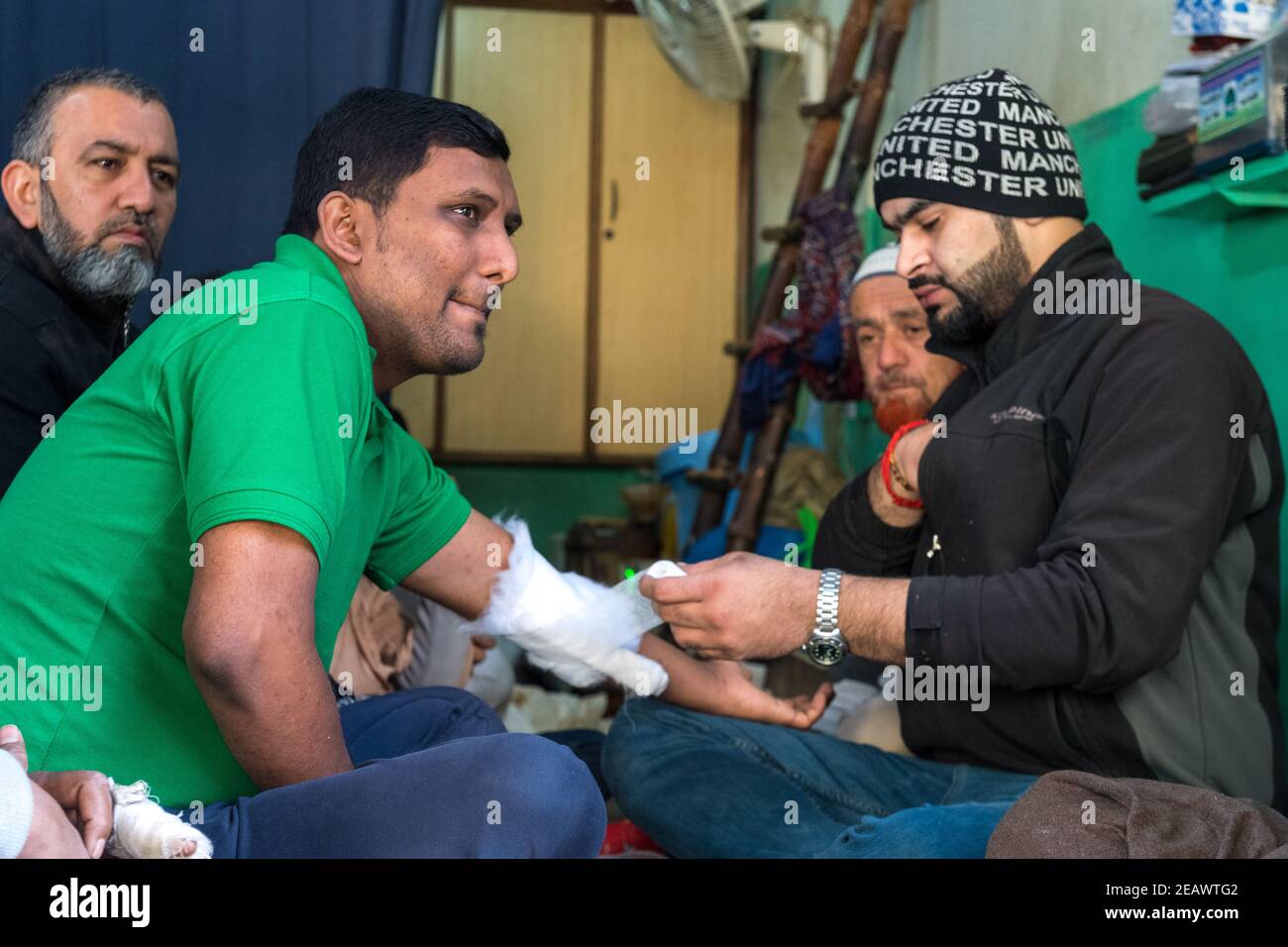 Street 'doctor' applying bandage, Traditional Medicine, Lahore, Punjab, Pakistan Stock Photo