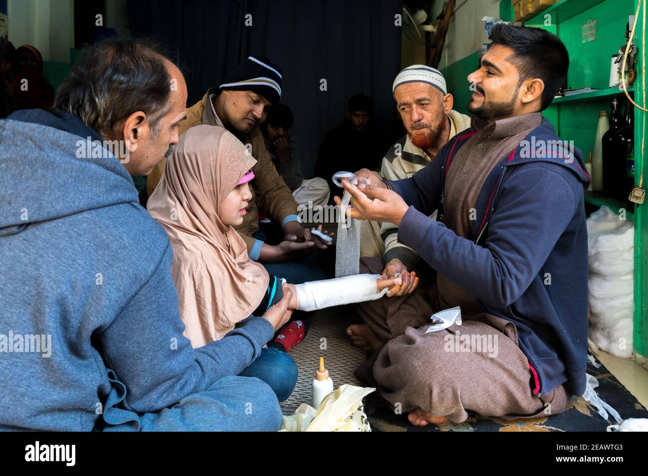 Street 'doctor' applying bandage, Traditional Medicine, Lahore, Punjab, Pakistan Stock Photo