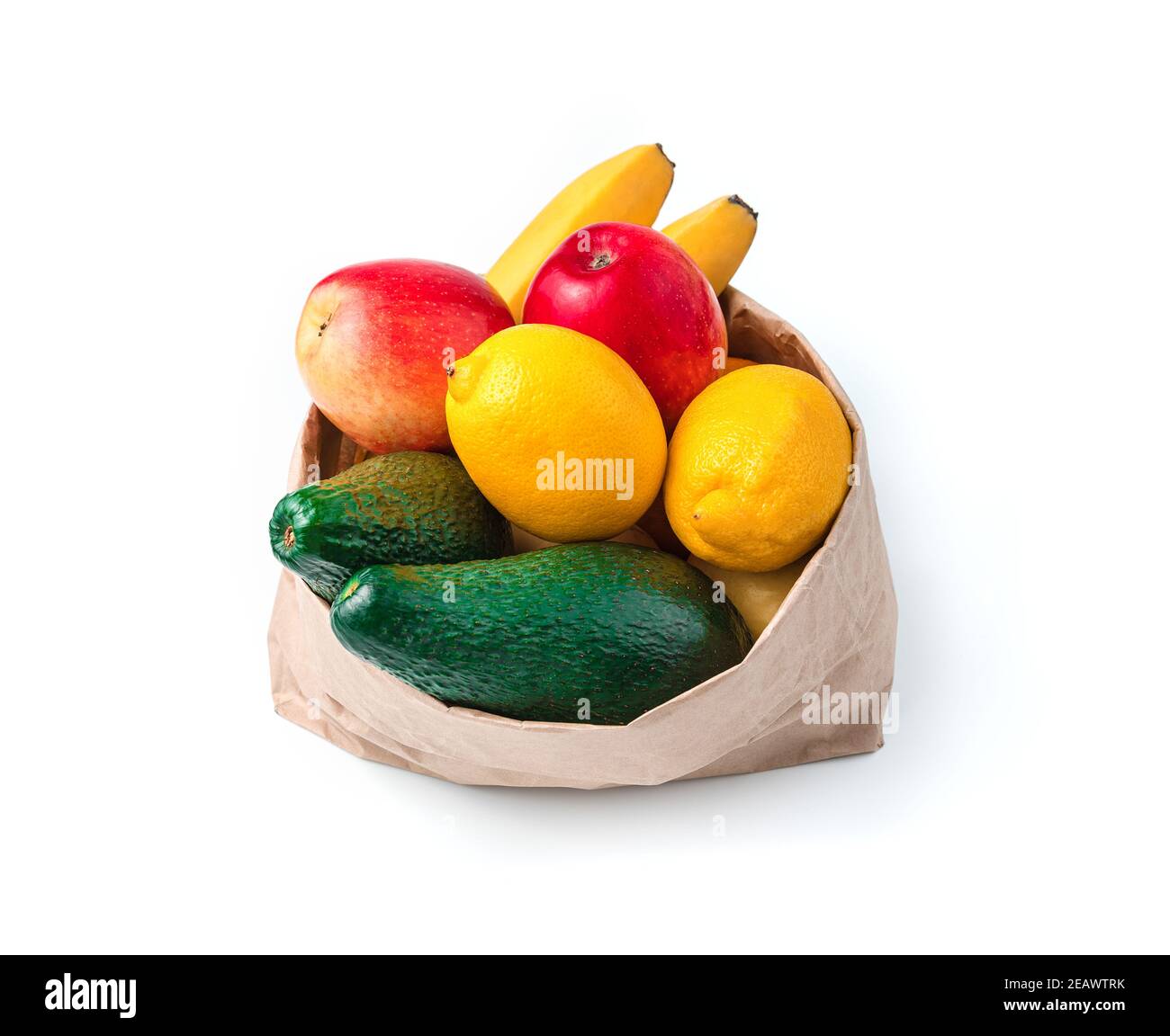 Avocados, lemons, bananas and apples in a paper bag isolated on a white