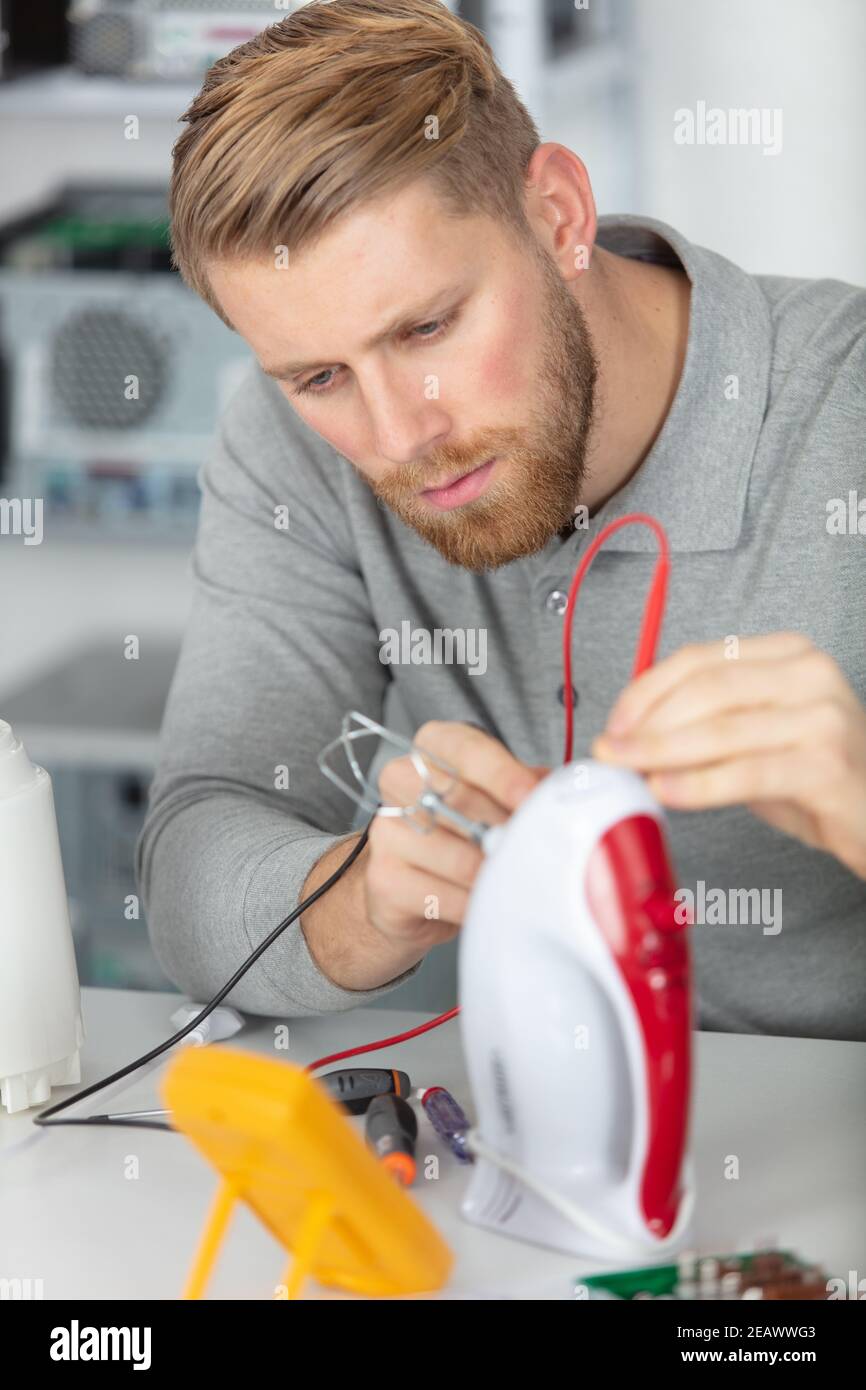 young male technician checking appliance Stock Photo
