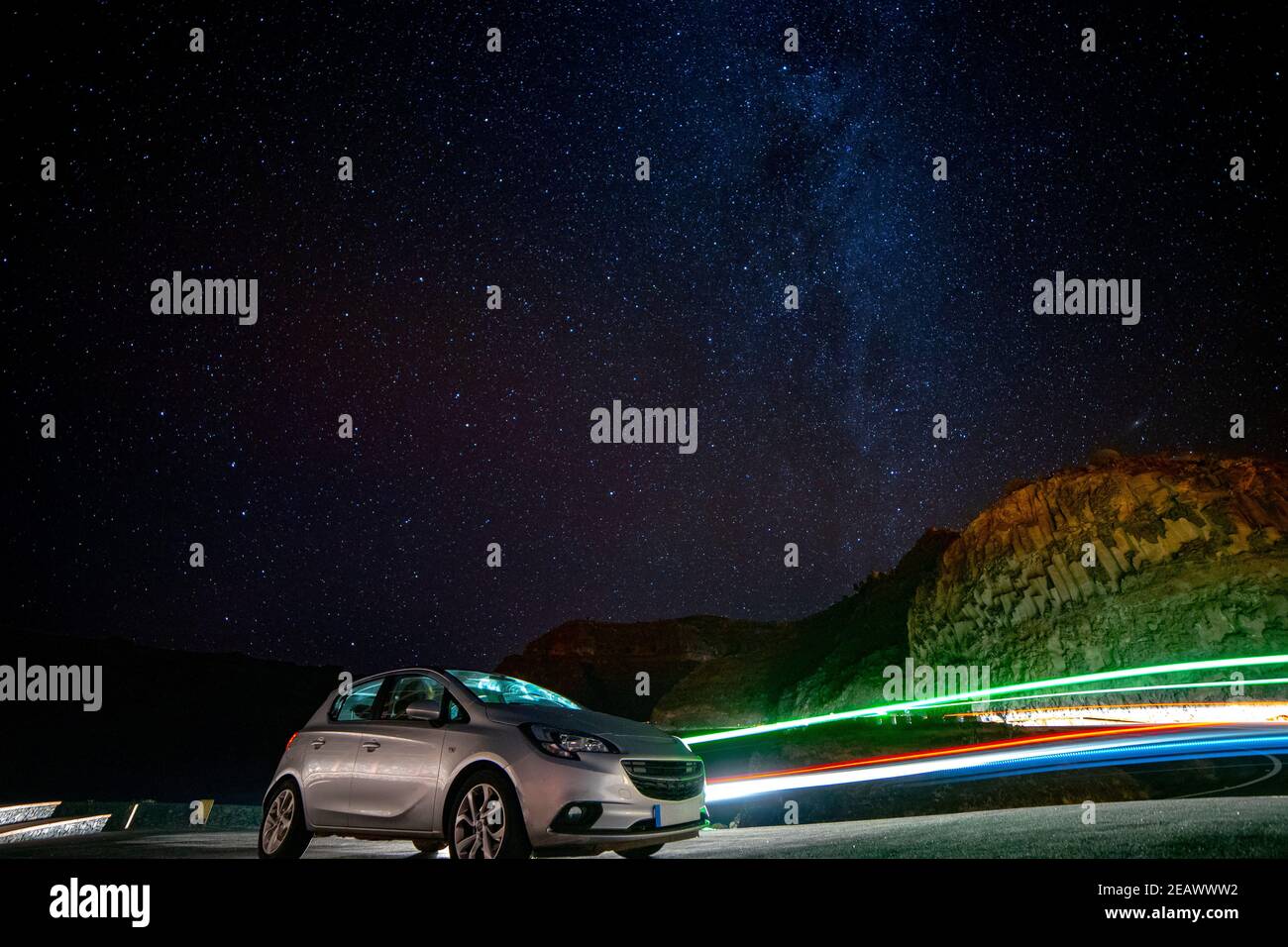 Long exposure of car in front of milky way with light trails of taxi ...