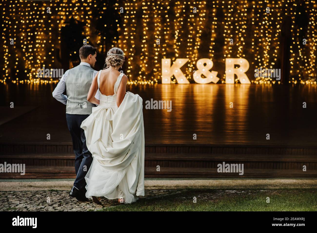 Young couple at their wedding walking towards a reception full of ...