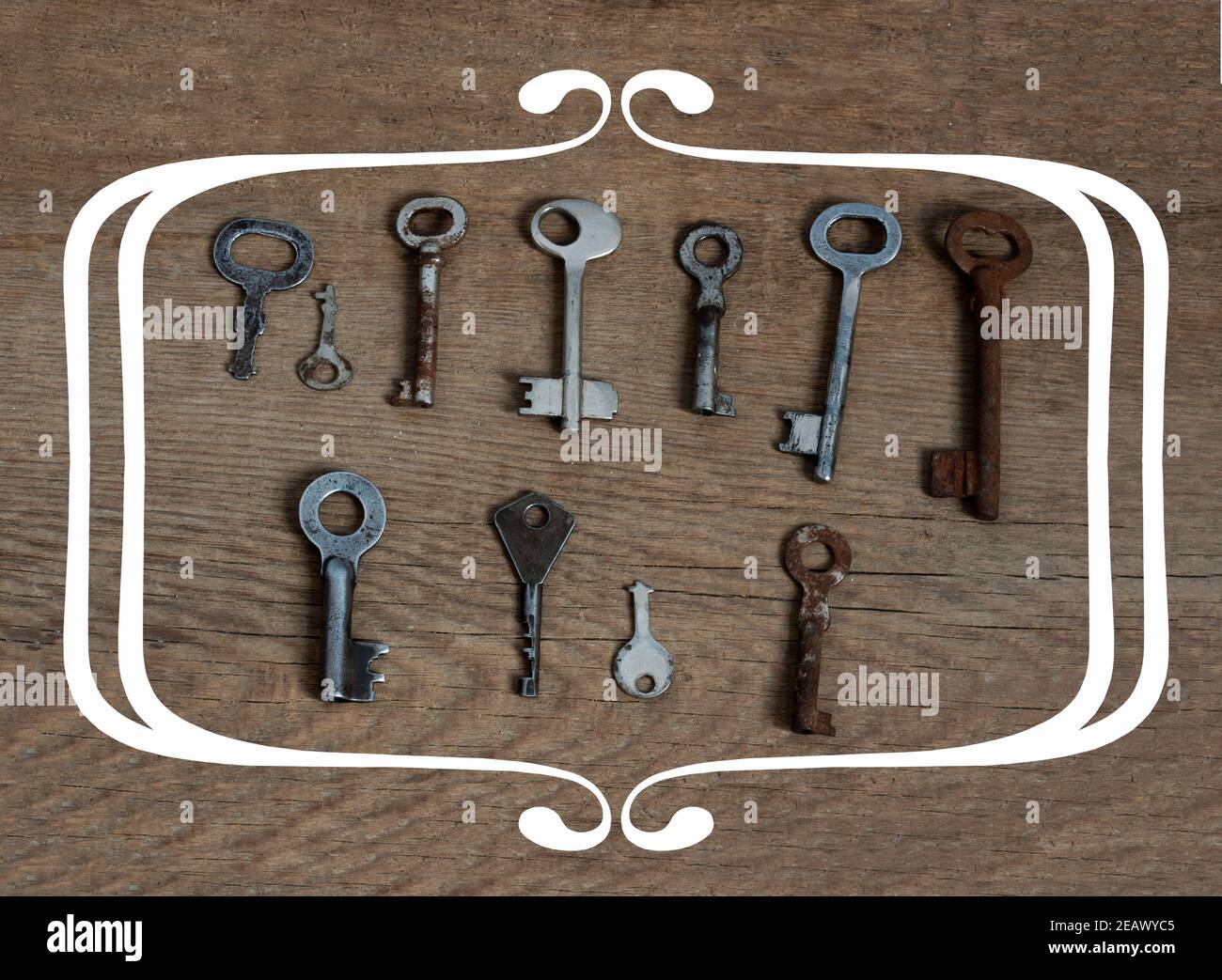 Old fashioned keys on wooden aged background with frame concept for text Stock Photo