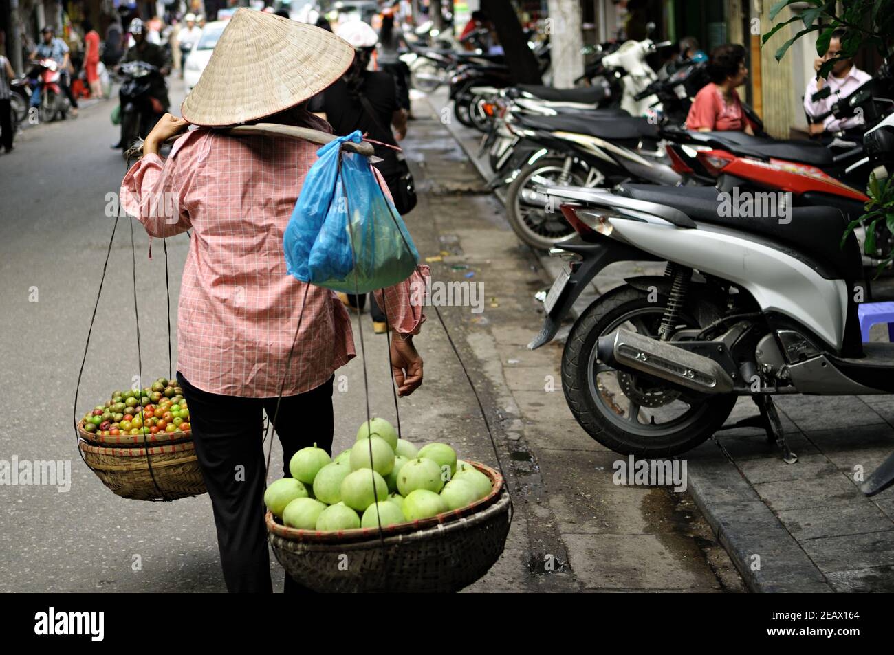 Woman street vendor with a conical hat, Hanoi, Vietnam Stock Photo