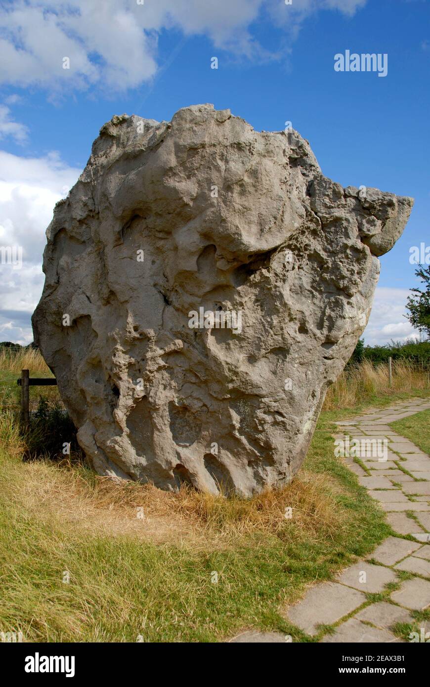 Large stone beside paved footpath, Avebury, Wiltshire, England Stock Photo