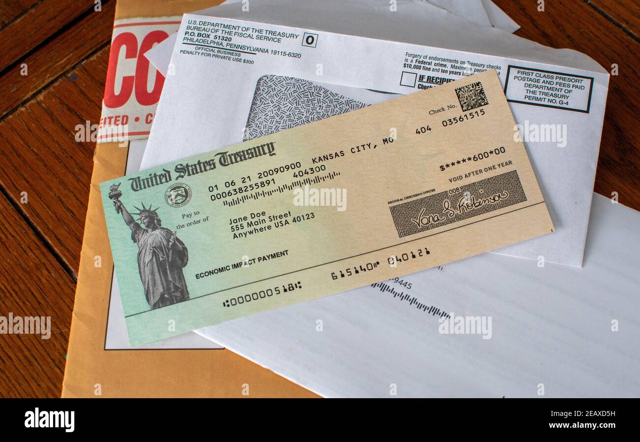 A stack of mail holds an important check from the united states treasury, a check for covid relief during this pandemic Stock Photo
