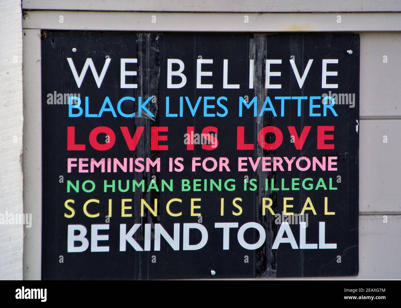 sign on building during black lives matter protestshow concern t for feminism , illegal imigratiion science beings real, love is love a all Stock Photo