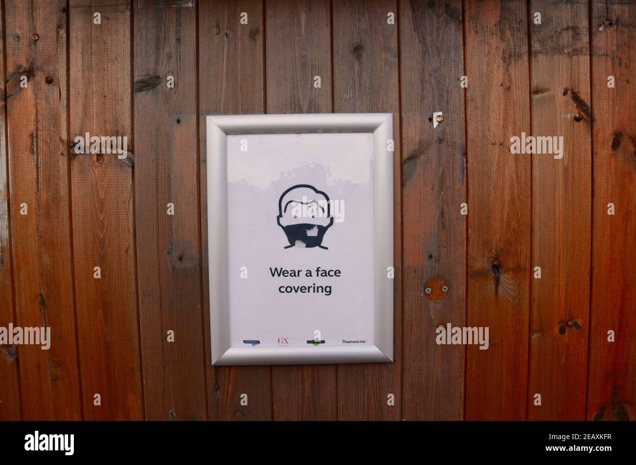 a wear a face covering framed poster on a station wall haringey london england uk Stock Photo