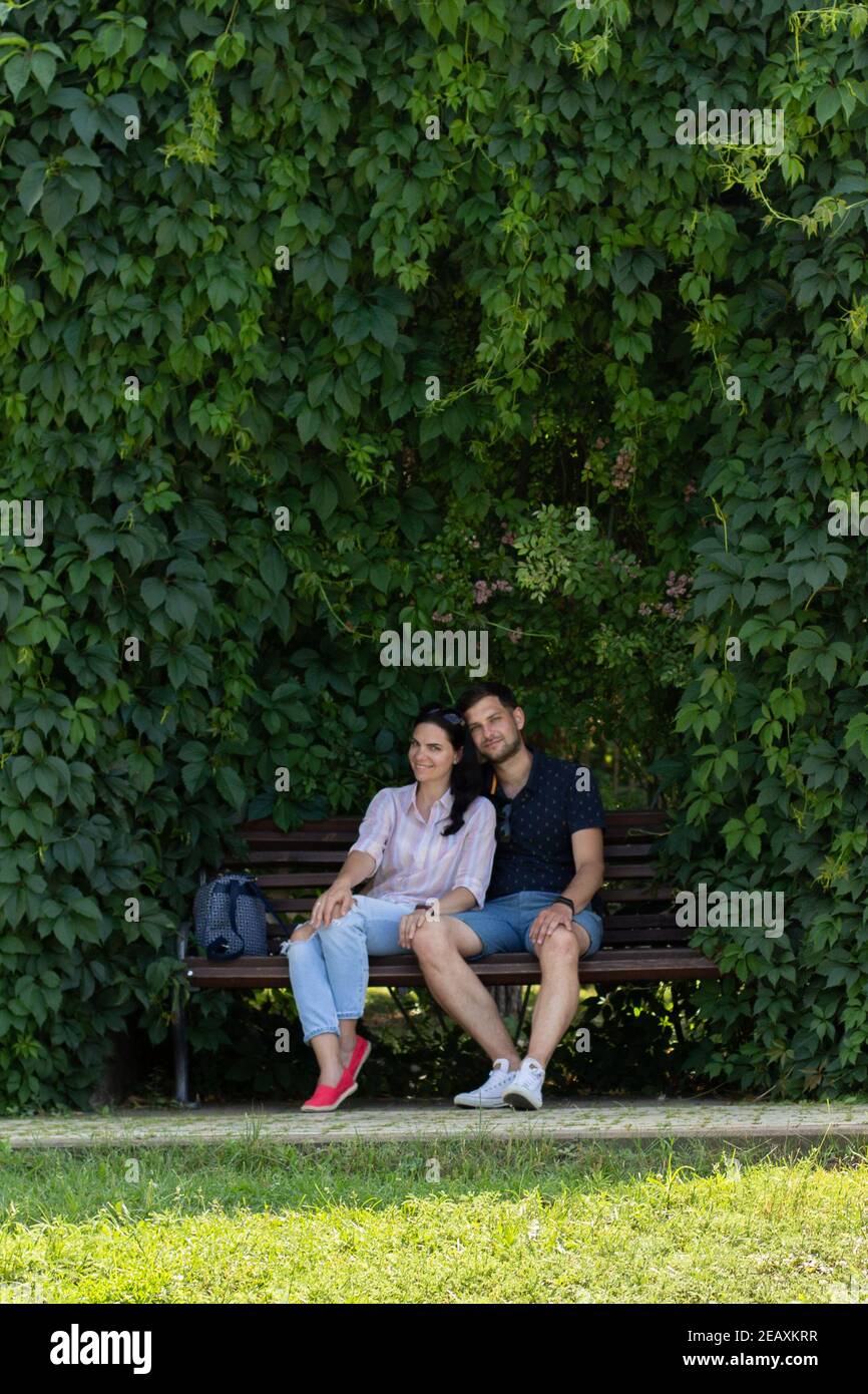 guy with a girl sitting on a bench in the park in summer Stock Photo ...