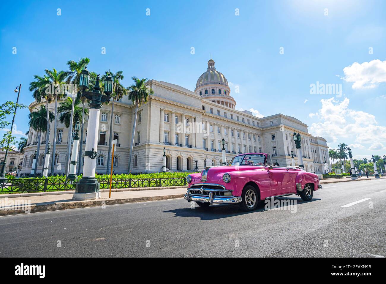 A vintage American retro carconvertible rides on an asphalt road in front of the Capitol in old town Havana. Tourist taxi cabriolet. Stock Photo