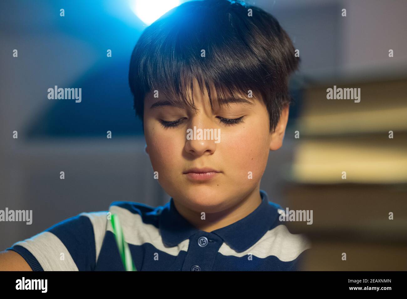 concentrated face of the child. the boy's eyes are downcast and he is busy with work. Stock Photo