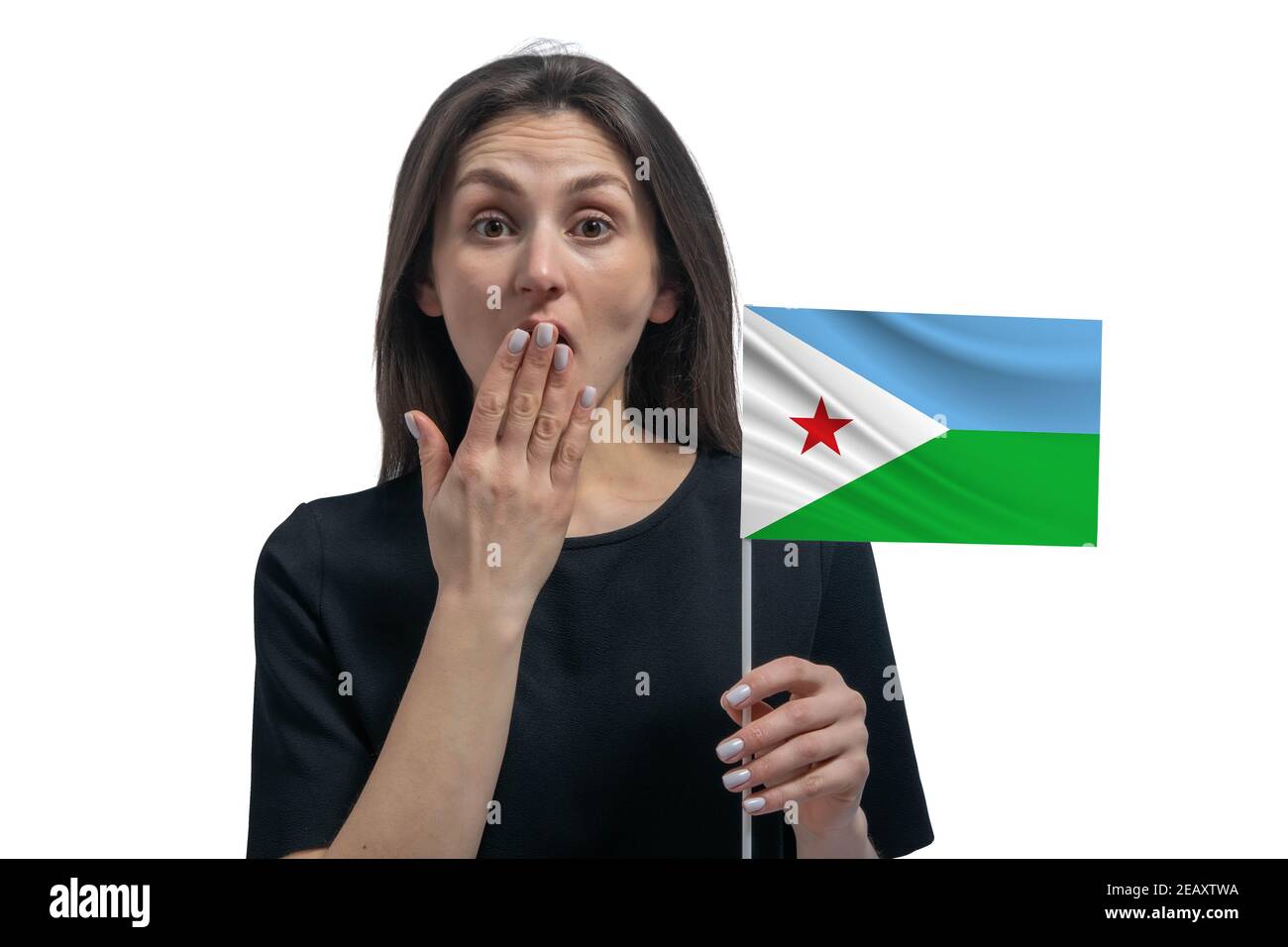 Happy young white woman holding flag of Djibouti and covers her mouth with her hand isolated on a white background. Stock Photo