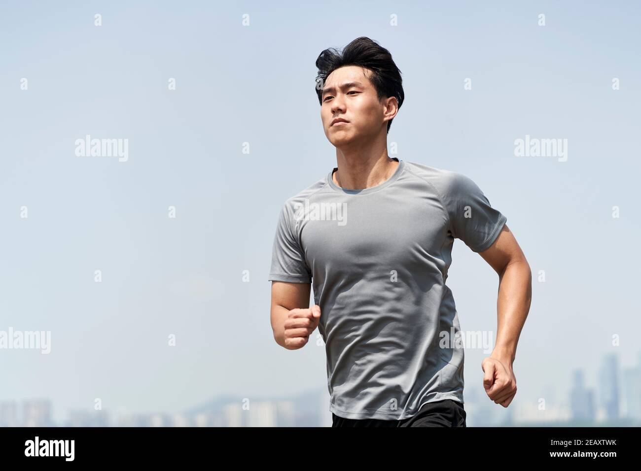 young asian man male runner jogger running jogging outdoors Stock Photo