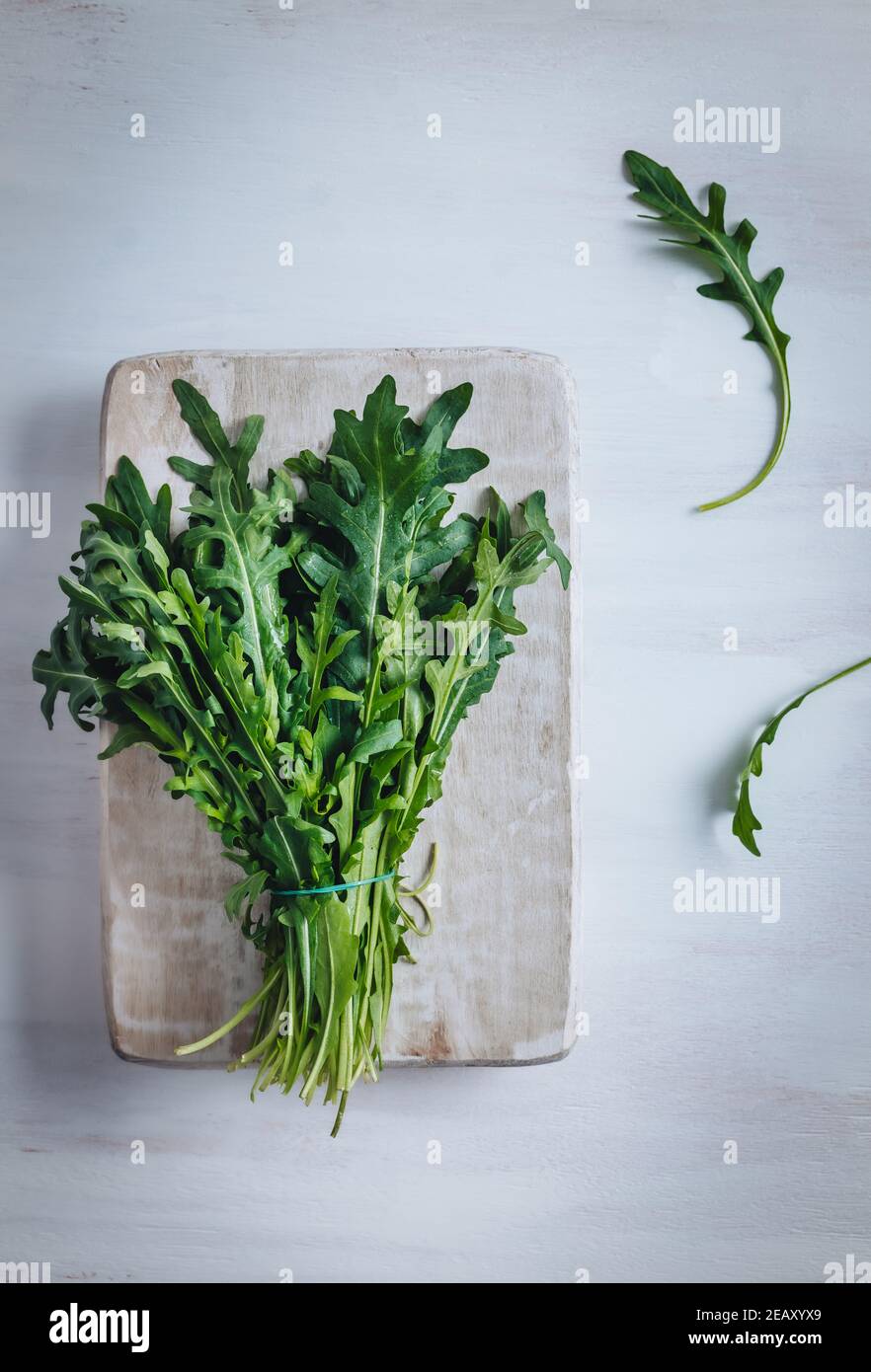 A bunch of fresh rocket leaves on a wooden table Stock Photo