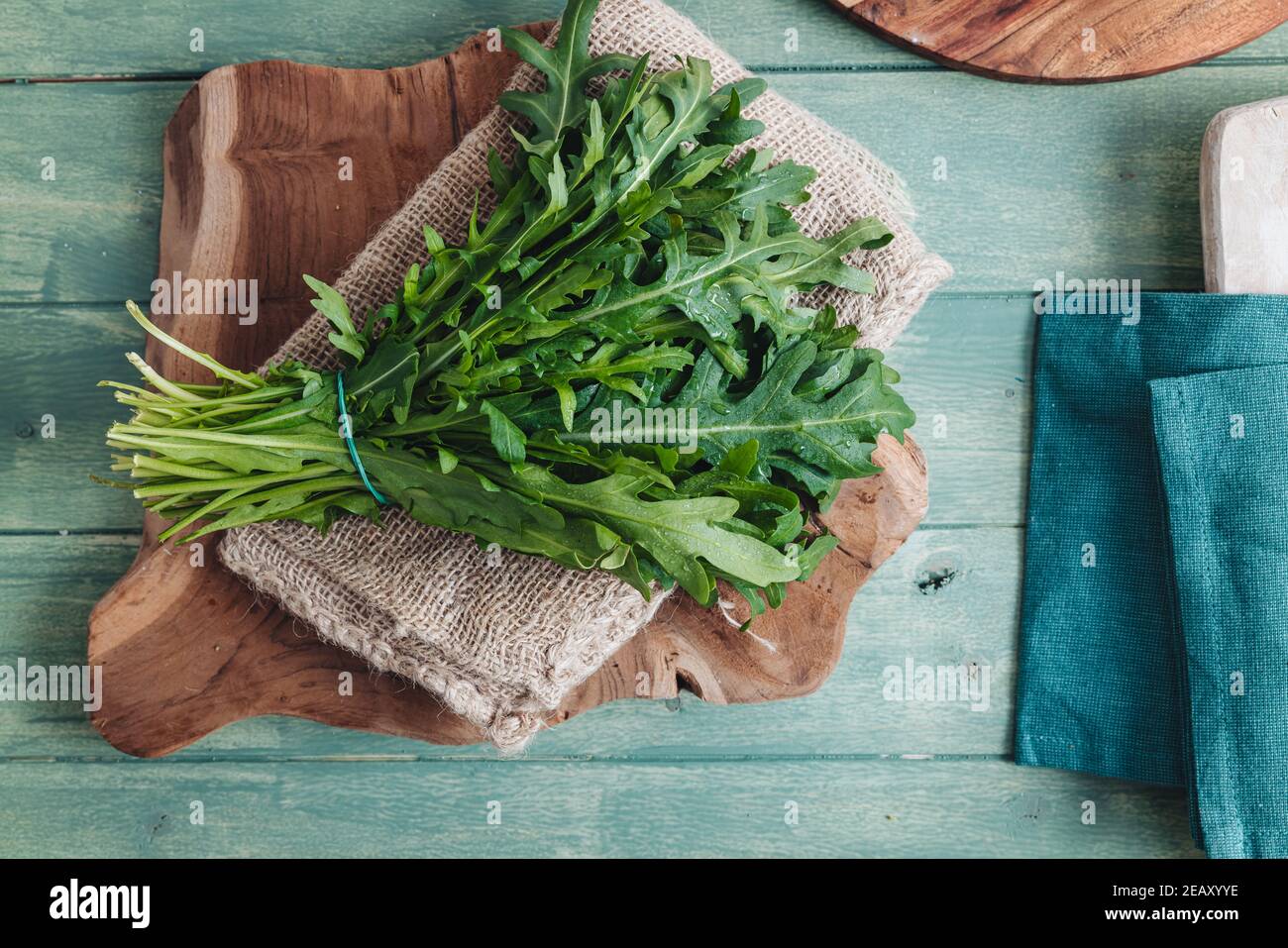 A bunch of fresh rocket leaves on a wooden table Stock Photo