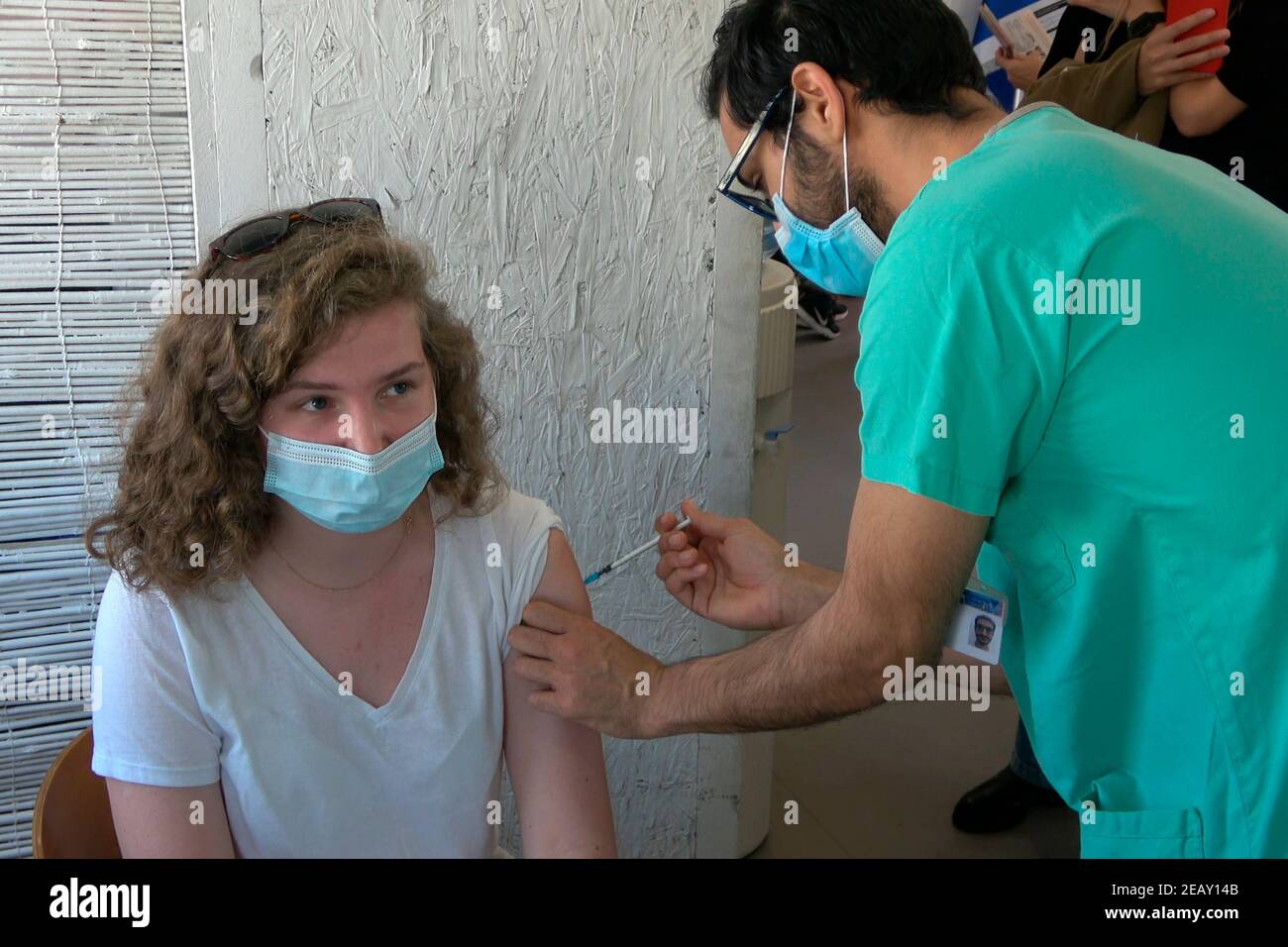 A medical worker administers the Pfizer-BioNTech COVID-19 vaccine to a foreign resident at the Sourasky Medical Centre for foreign nationals on February 09, 2021, in Tel Aviv, Israel. A month and a half after Israel launched its world-leading coronavirus vaccination campaign, Tel Aviv-Yafo Municipality and the Sourasky Medical Center (Ichilov Hospital) started administering Pfizer-BioNTech coronavirus vaccines free of charge to the city's foreign nationals, many of whom are undocumented asylum seekers. Stock Photo