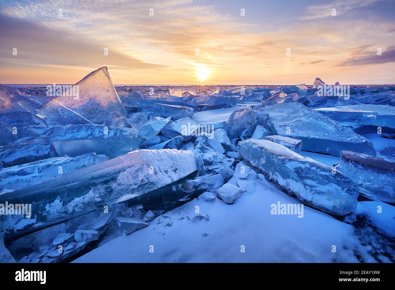 Beautiful landscape of Ice hummock with flare of sunset light at ice of lake Baikal, Russia Stock Photo