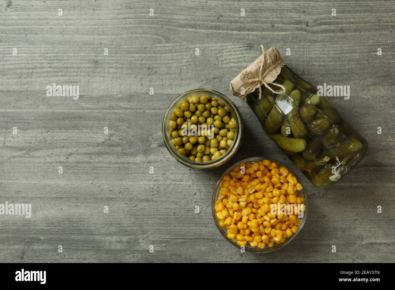 Pickled cucumbers, corn and peas on gray background Stock Photo