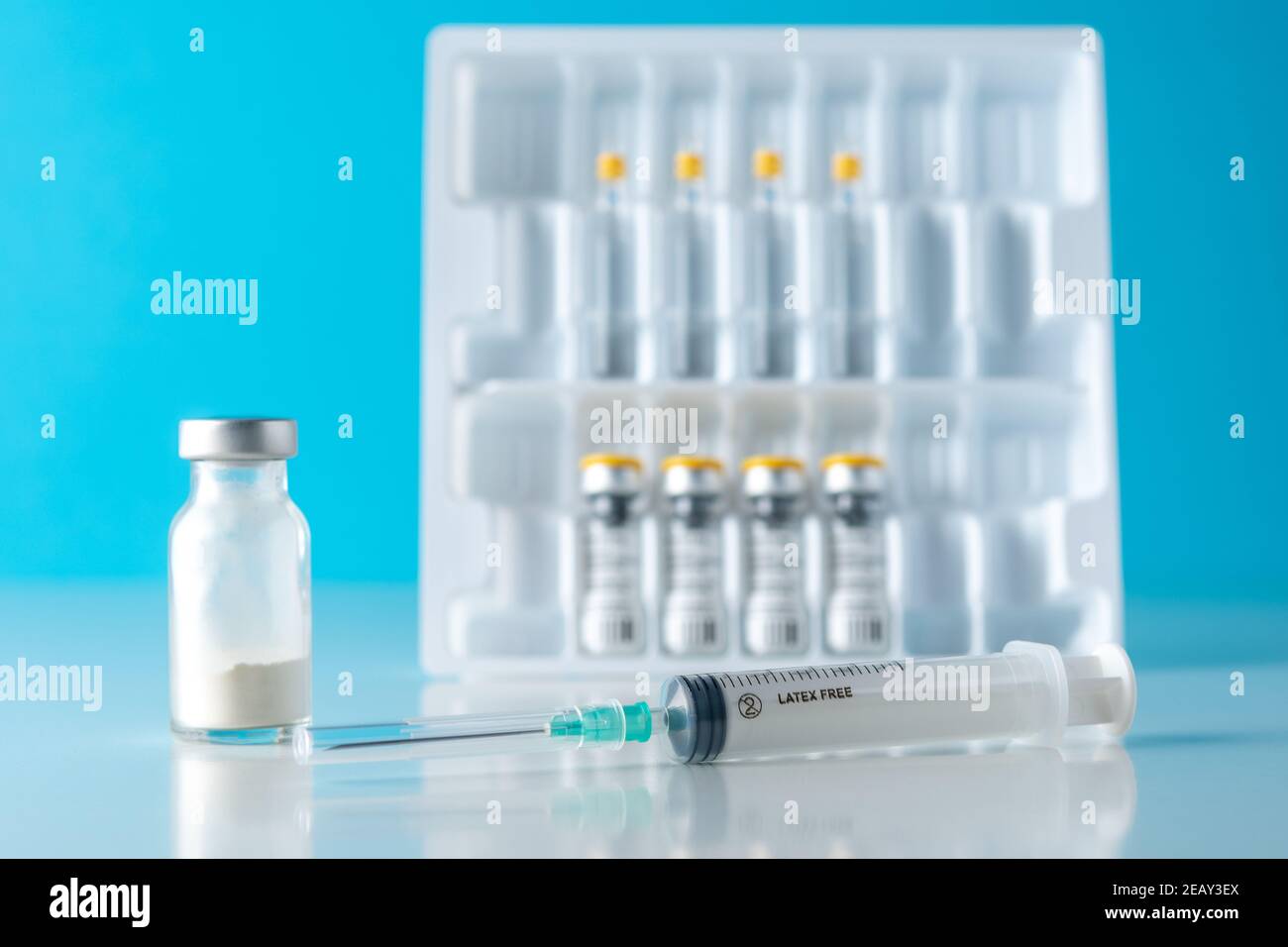 Vaccine vial glass with a syringe on blue background. Medicine ...