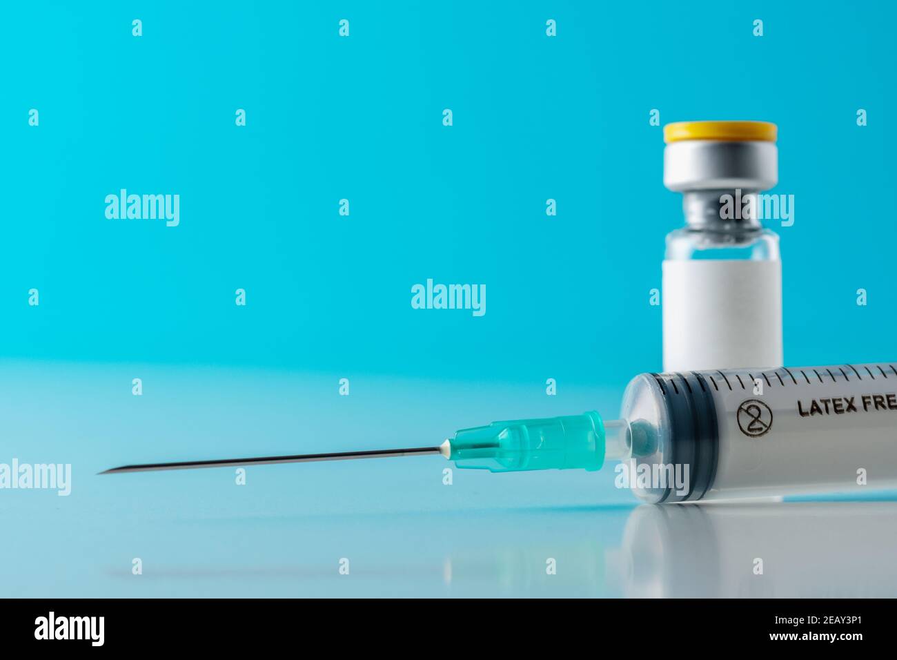 Vaccine vial glass with a syringe on blue background. Medicine ...