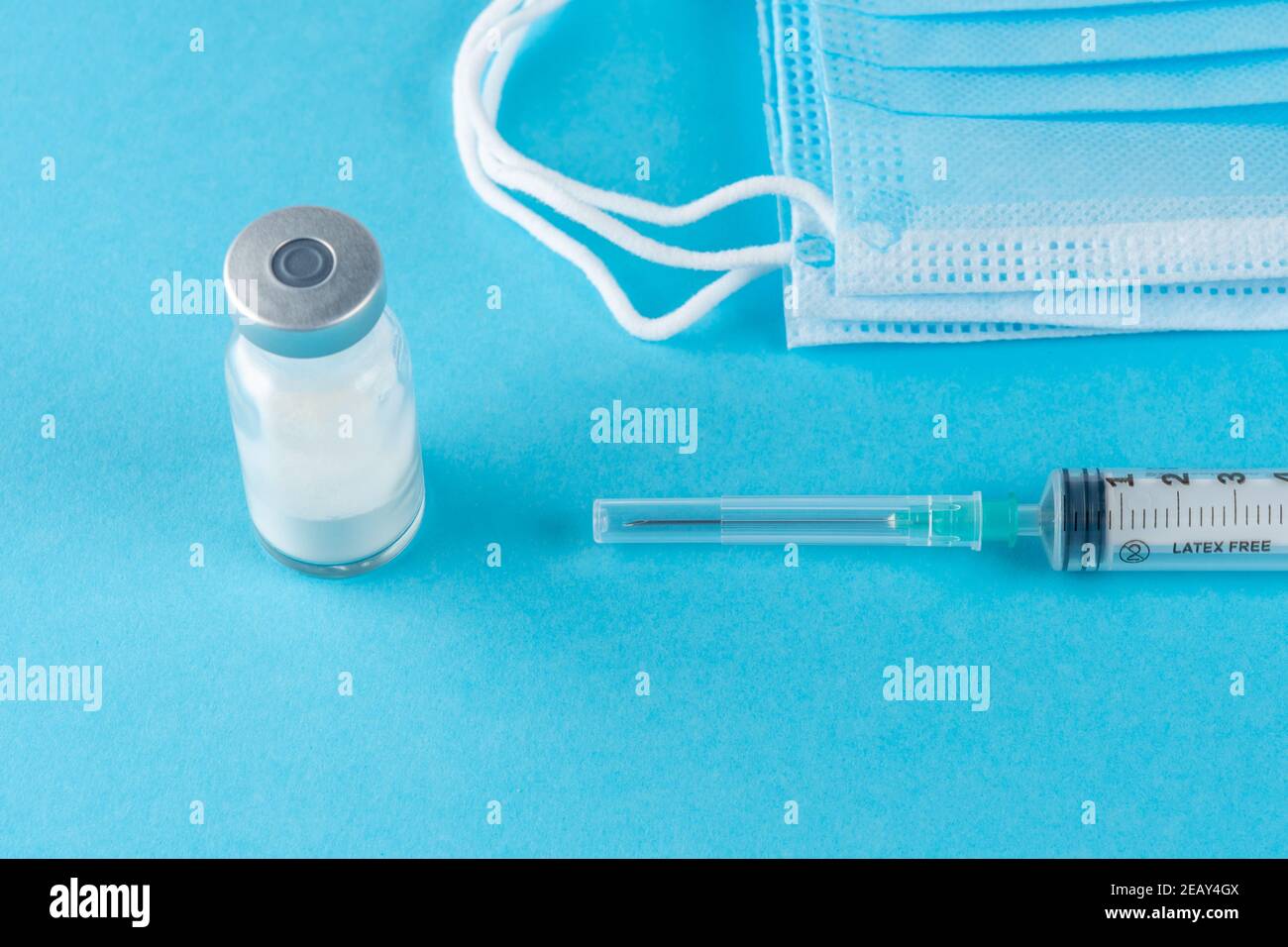 Vaccine vial glass with a syringe on blue background. Medicine ...