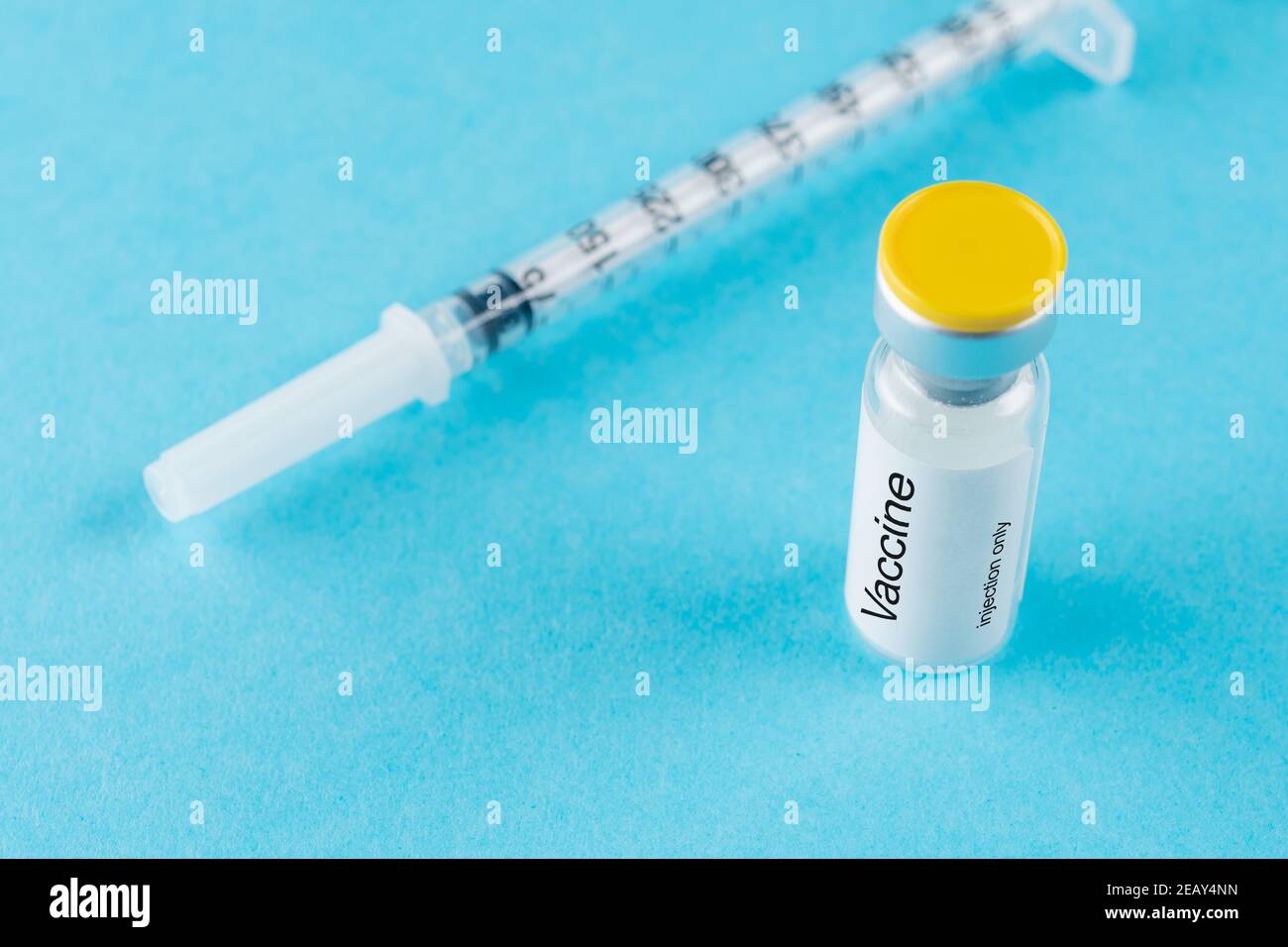 Vaccine vial glass with a syringe on blue background. Medicine ...