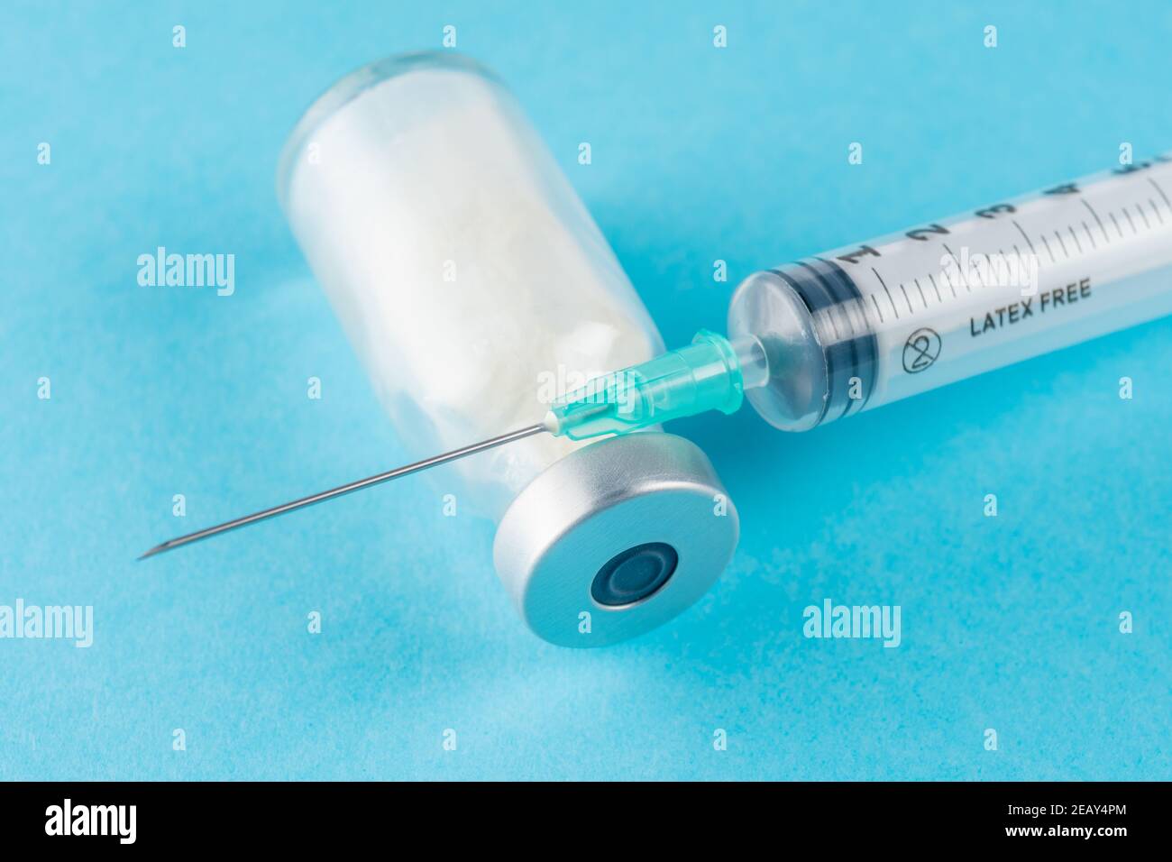 Vaccine vial glass with a syringe on blue background. Medicine ...