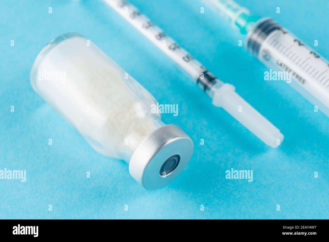Vaccine vial glass with a syringe on blue background. Medicine ...