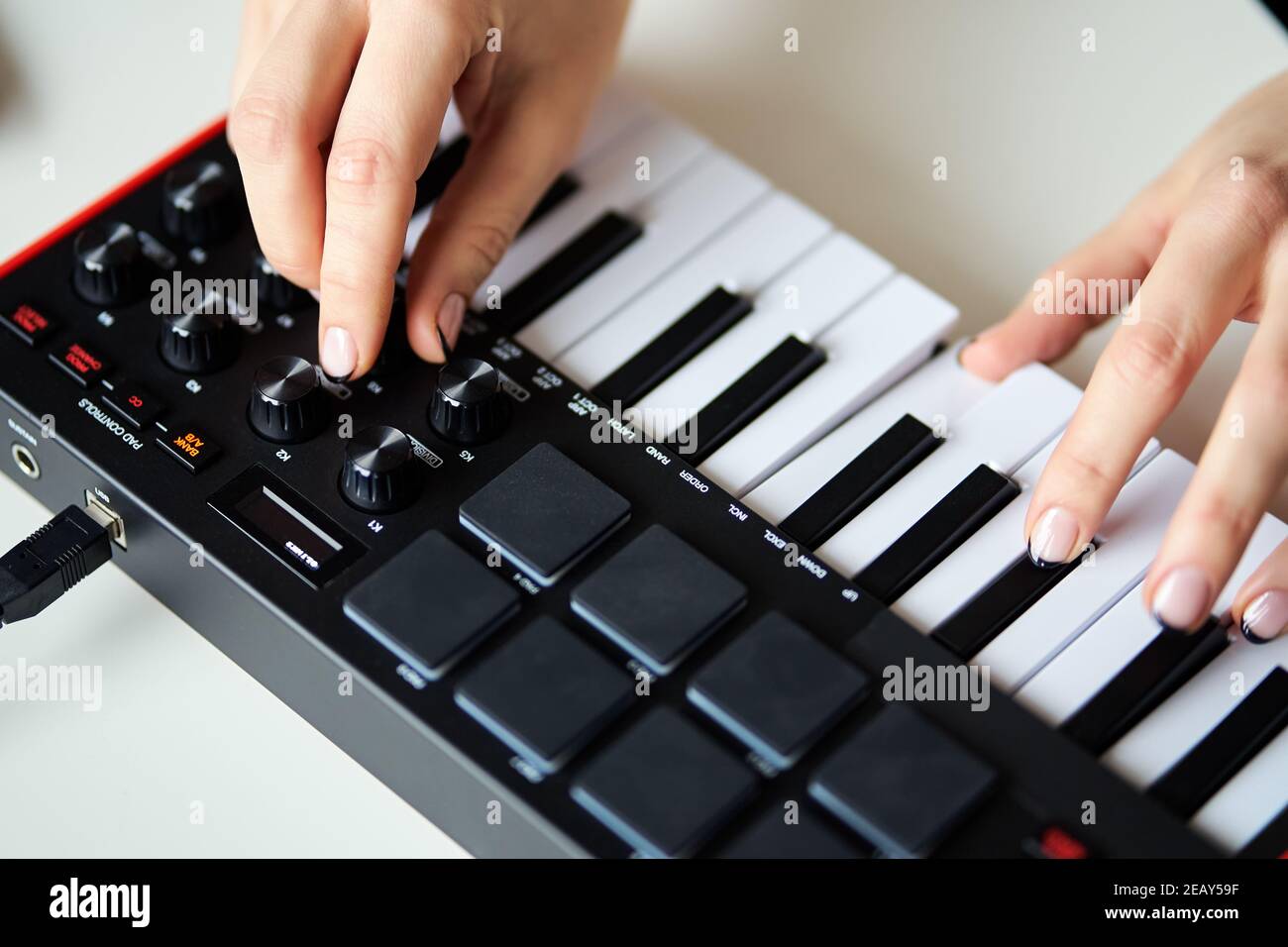 Woman playing a small modern music synthesizer Stock Photo