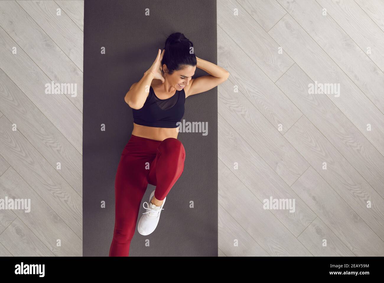 Top view of sporty active woman doing cross training bicycle crunches trains leg muscles and abs. Stock Photo