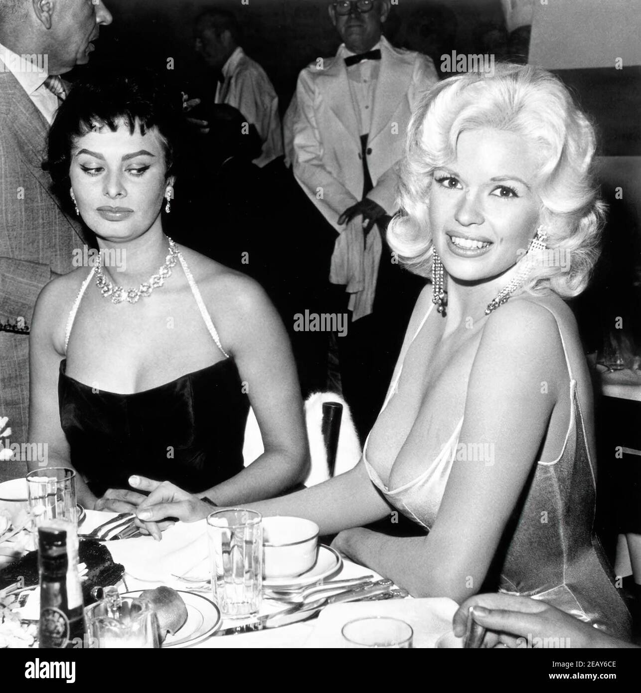 American actress and model Jayne Mansfield, known for her publicity stunts, attended a dinner at the exclusive Beverly Hills Romanoff's restaurant hosted by Paramount Pictures to officially welcome Italian actress Sophia Loren to Hollywood. A photograph of the two women, with Loren casting a sideways glance at Mansfield's cleavage, was distributed world-wide and became an international sensation. Stock Photo