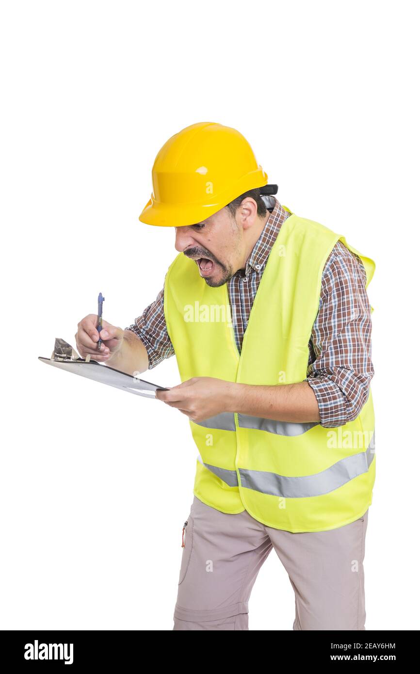 Anxious male builder in hardhat and reflective vest taking notes on clipboard in hurry while standing on white background Stock Photo