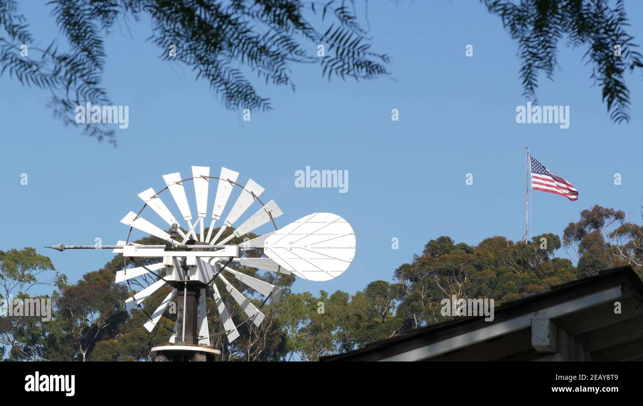Classic retro windmill, bladed rotor and USA flag against blue sky ...