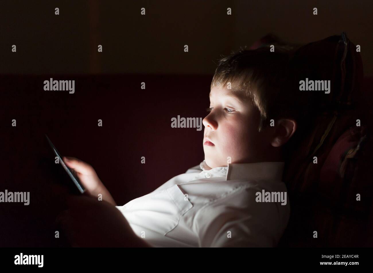 A 9 year old boy using a tablet in the evening Stock Photo