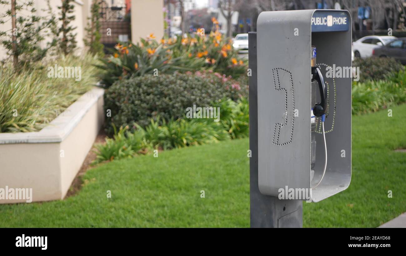 Retro coin-operated payphone station for emergency call on street, California USA. Public analog pay phone booth. Outdated technology for connection a Stock Photo