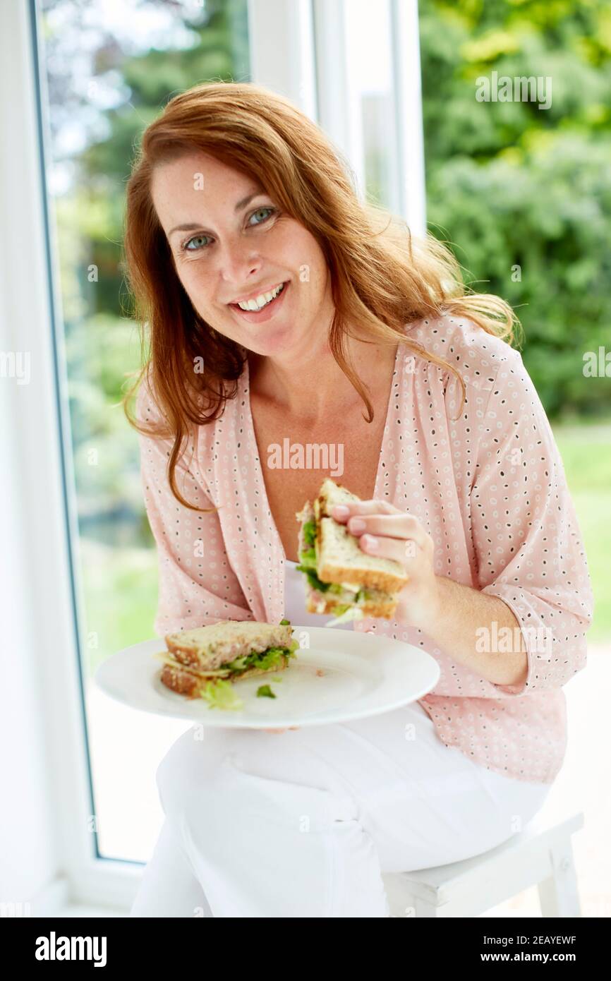 Woman eating a sandwich Stock Photo