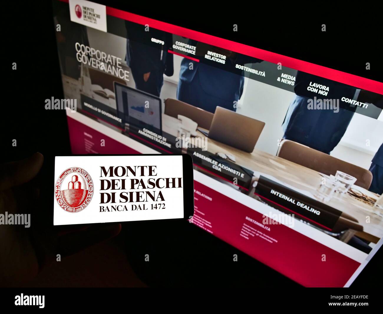 Person Holding Cellphone With Logo Of Italian Bank Banca Monte Dei Paschi Di Siena Bmps On Screen In Front Of Webpage Focus On Phone Display Stock Photo Alamy