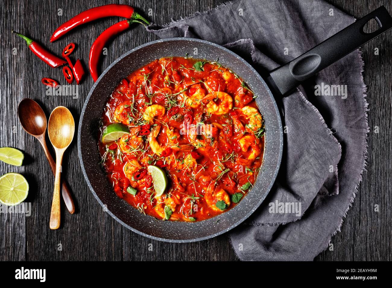 https://c8.alamy.com/comp/2EAYH9M/prawn-karahi-pakistani-tomato-shrimp-curry-with-lime-juice-red-chili-and-red-curry-paste-served-on-a-frying-pan-with-fresh-cilantro-on-a-dark-wooden-2EAYH9M.jpg