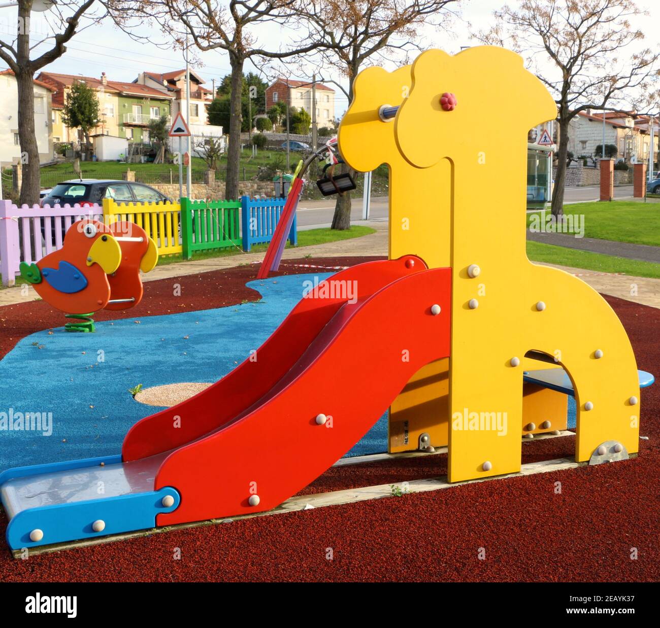 Colourful wooden giraffe shaped slide and ride on parrot in a childrens