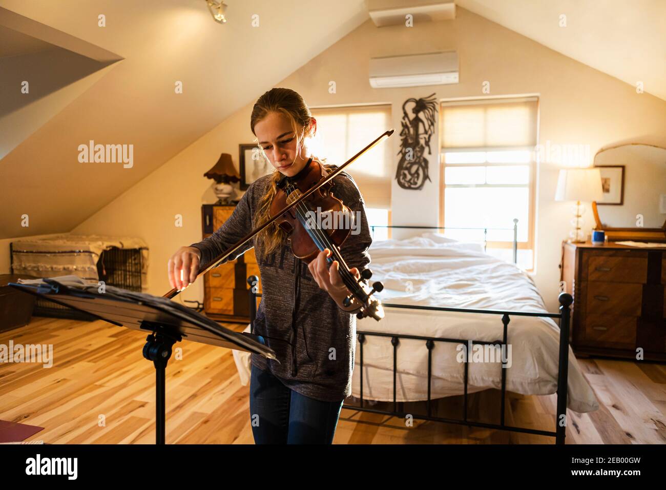 Teenage girl playing her violin in her bedroom Stock Photo Alamy