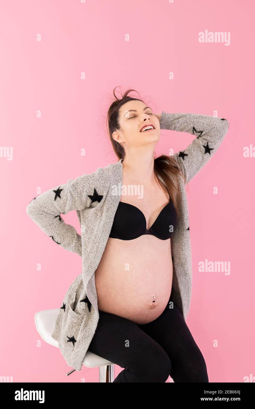 Foto de Pregnant woman hold belly in casual underwear over the
