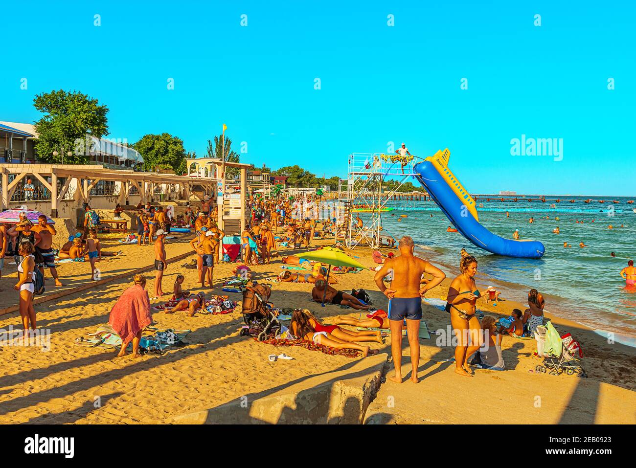A large gathering of people in the summer season on the sandy beach in the resort town Stock Photo