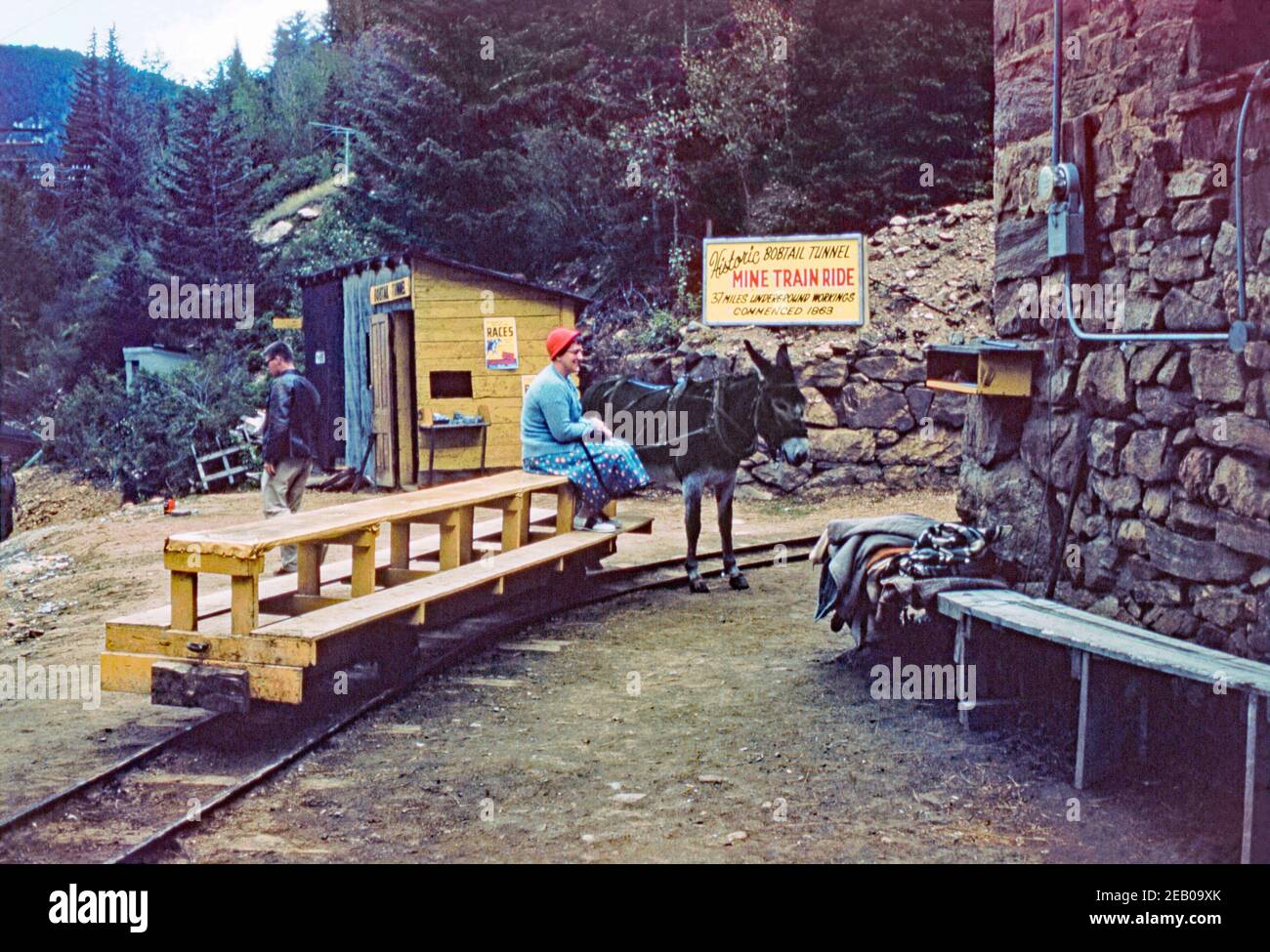 A woman seated onboard a narrow-gauge rail ‘carriage’ pulled by a donkey at the Bobtail Tunnel tramway near Black Hawk, Gilpin County, Colorado, USA c. 1957. This tourist attraction must have been quite cold, as blankets lie in a pile (right). The train-ride visitor attraction into the mine workings lasted until 1984. This image is from an old American amateur colour transparency – a vintage 1950s photograph. Stock Photo