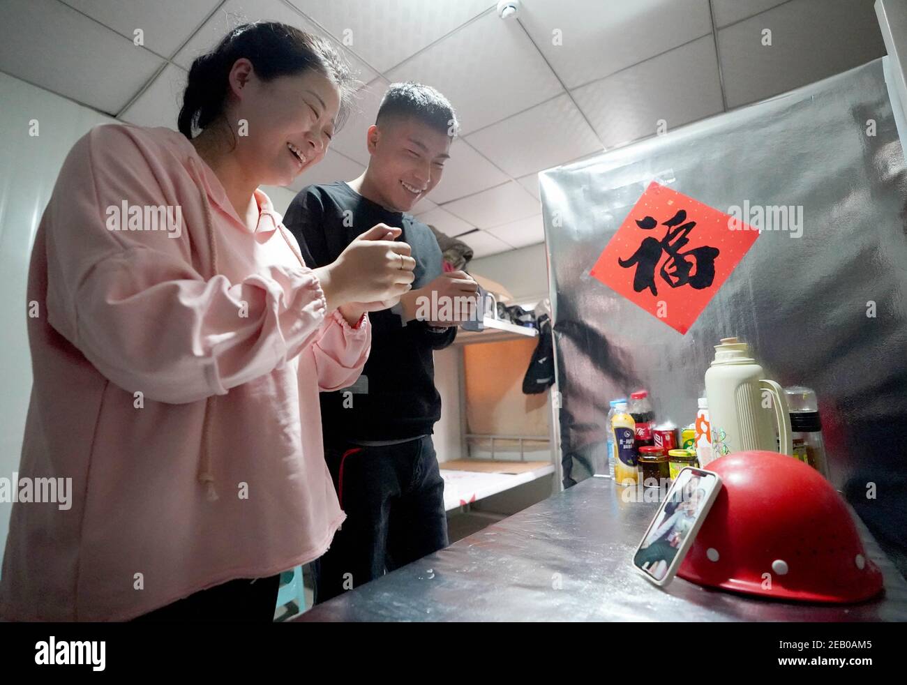 Beijing, China. 11th Feb, 2021. Wang Yizhu (L) and Du Yan, a couple from Changchun in northeast China's Jilin Province working for the construction project of Fengtai Railway Station, pay a new year call to Wang Yizhu's parents, in Beijing, capital of China, Feb. 11, 2021. This marks the couple's first time to spend the Spring Festival holiday in Beijing. This year's Spring Festival falls on Friday. Credit: Wang Yuguo/Xinhua/Alamy Live News Stock Photo
