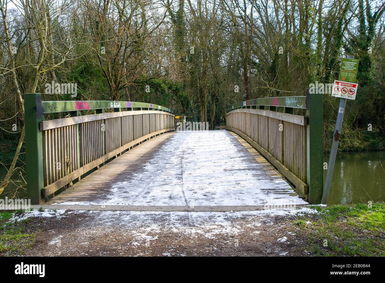 Denham, Buckinghamshire, UK. 11th February, 2021. Snow still sits on a bridge across the River Colne. Following recent heavy rainfall the River Colne in Denham Country Park has burst its banks. Due to sustained freezing temperatures, both patches of snow and flooding remain in parts of the park. Credit: Maureen McLean/Alamy Live News Stock Photo